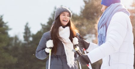 Kobieta i mężczyzna z kijkami - aktywność fizyczna zimą